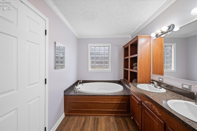 bathroom featuring a tub, hardwood / wood-style flooring, vanity, ornamental molding, and a textured ceiling