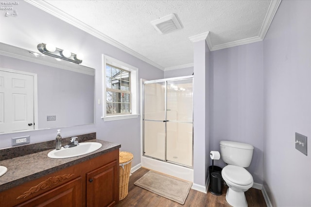 full bathroom with enclosed tub / shower combo, hardwood / wood-style floors, vanity, ornamental molding, and toilet