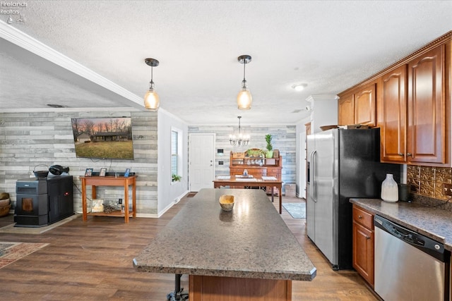 kitchen with crown molding, stainless steel appliances, dark wood-type flooring, and hanging light fixtures