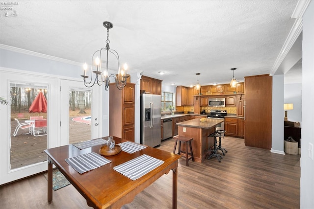 dining room with dark hardwood / wood-style flooring, a notable chandelier, crown molding, and a textured ceiling