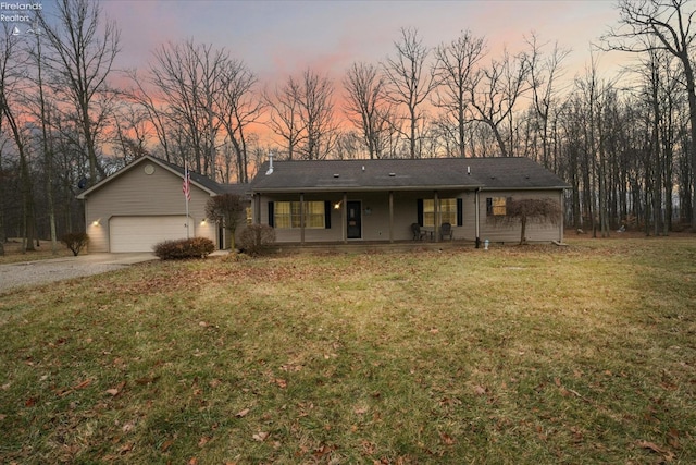 single story home with a yard, a garage, and covered porch