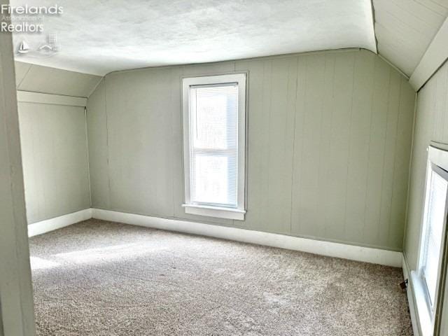 bonus room featuring carpet, baseboards, and vaulted ceiling