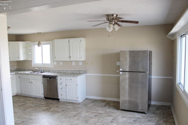 kitchen featuring stainless steel appliances, sink, white cabinets, and ceiling fan