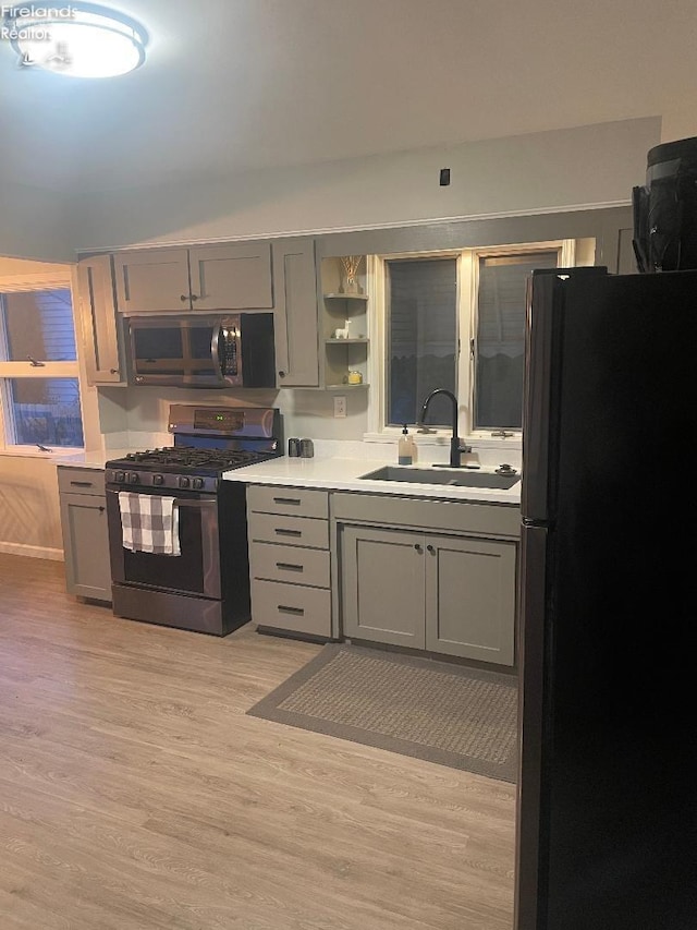 kitchen with light hardwood / wood-style flooring, sink, gray cabinets, and appliances with stainless steel finishes