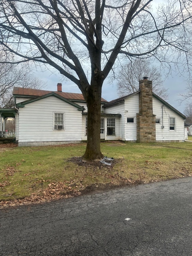 view of side of property with cooling unit and a yard