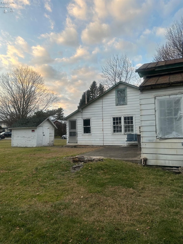 73 Center, Milan, OH 44846 - rear view of property with a storage shed, a patio, and a lawn