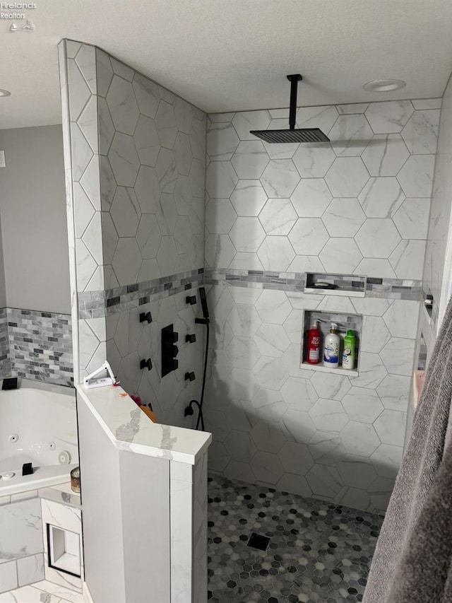 bathroom featuring a textured ceiling and separate shower and tub