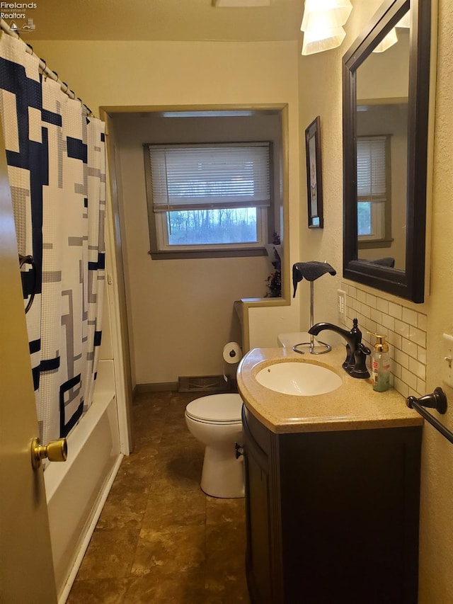 full bath with toilet, vanity, and tasteful backsplash
