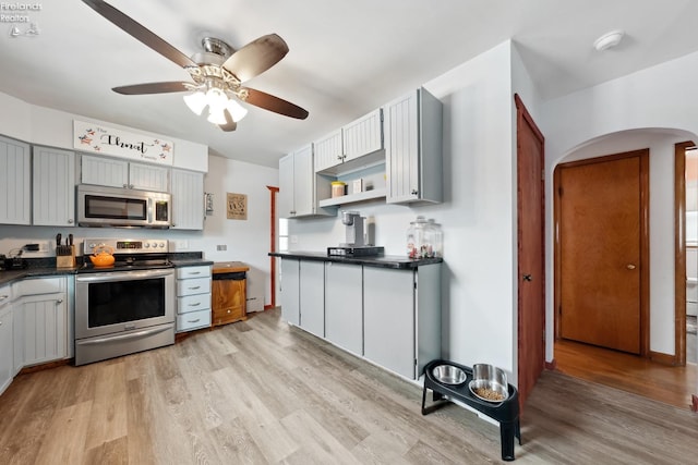 kitchen with ceiling fan, stainless steel appliances, gray cabinets, and light hardwood / wood-style flooring