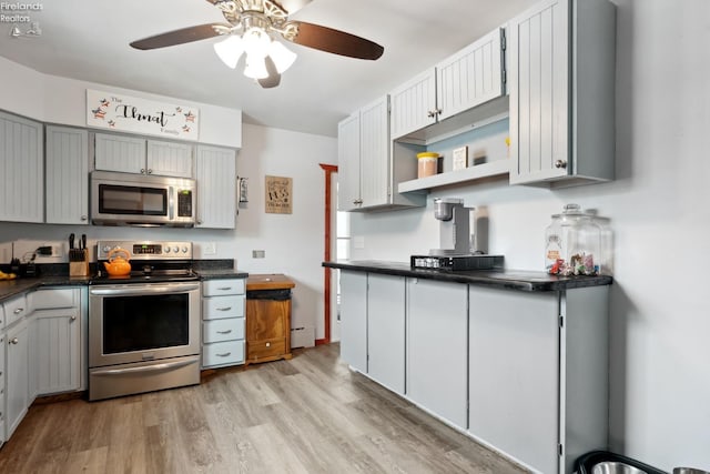 kitchen with gray cabinets, a baseboard heating unit, ceiling fan, stainless steel appliances, and light hardwood / wood-style flooring