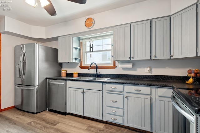 kitchen featuring appliances with stainless steel finishes, gray cabinets, sink, and light hardwood / wood-style flooring