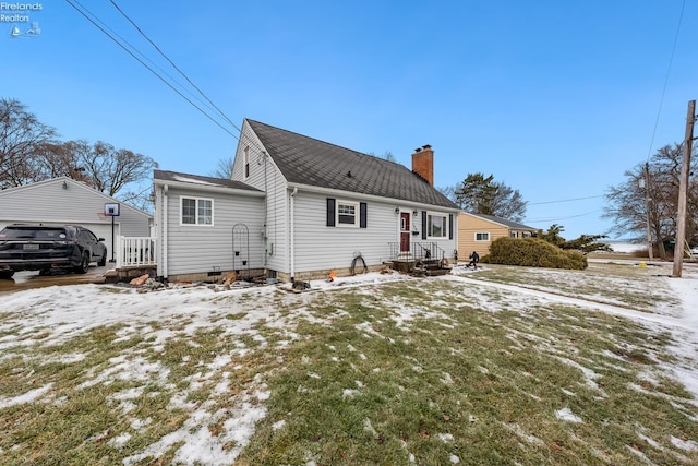 view of front of property with a garage, an outbuilding, and a lawn