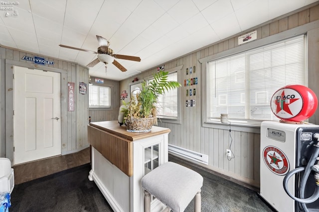 miscellaneous room with ceiling fan, a baseboard radiator, and wooden walls