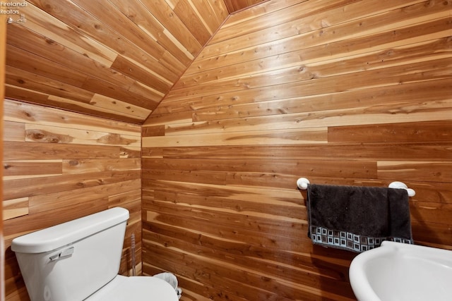 bathroom featuring lofted ceiling, wood ceiling, toilet, and wood walls