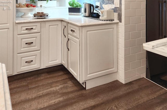 interior space featuring dark hardwood / wood-style flooring and white cabinets