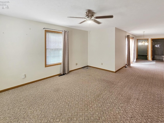 spare room with light carpet, visible vents, baseboards, and ceiling fan with notable chandelier