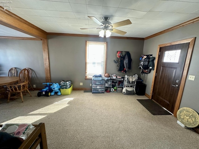 interior space with carpet, ceiling fan, and ornamental molding