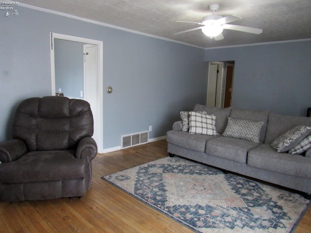 living room featuring hardwood / wood-style flooring, ornamental molding, and ceiling fan