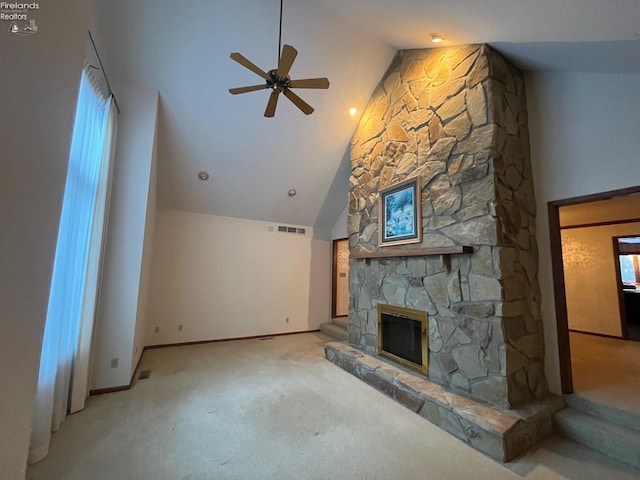 unfurnished living room featuring high vaulted ceiling, a stone fireplace, visible vents, a ceiling fan, and carpet