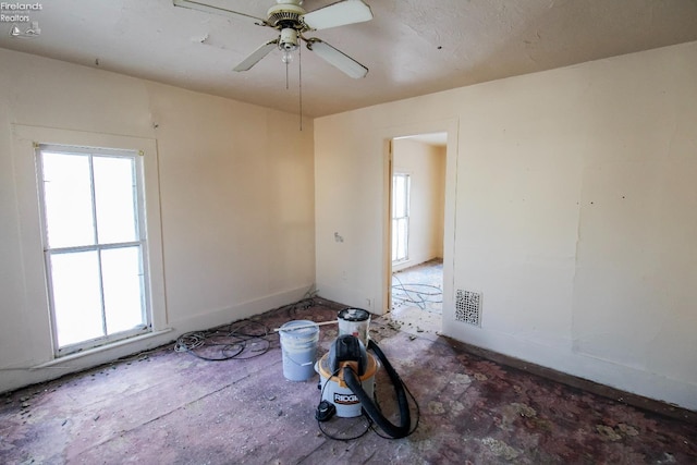 spare room featuring ceiling fan and a healthy amount of sunlight