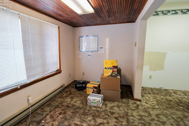 misc room featuring a baseboard heating unit, dark carpet, and wood ceiling