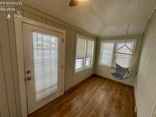 unfurnished sunroom with vaulted ceiling, ceiling fan, and wood ceiling