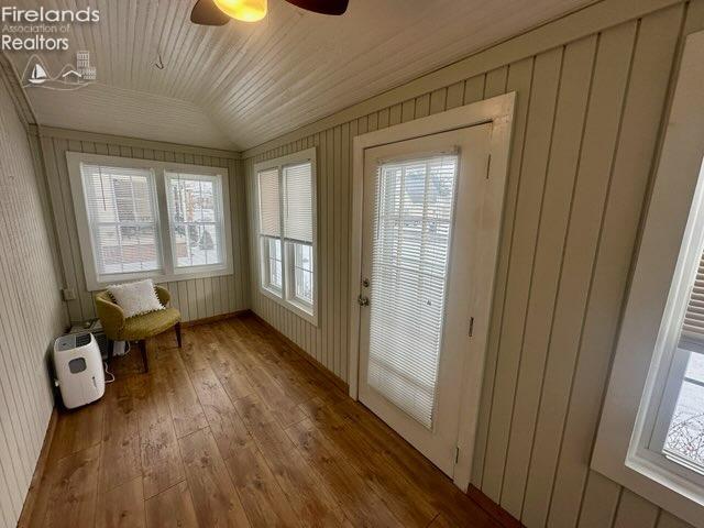 unfurnished sunroom with a healthy amount of sunlight, vaulted ceiling, and wood ceiling