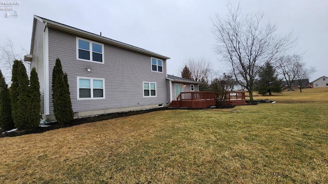 back of house featuring a lawn and a wooden deck