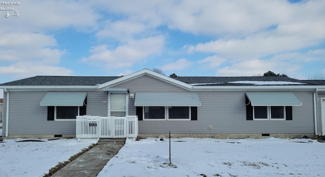 view of front of house featuring a shingled roof and crawl space