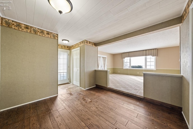 unfurnished room featuring baseboards and wood finished floors