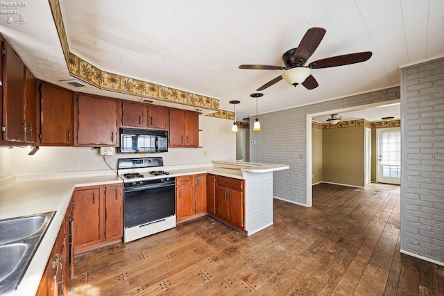 kitchen with light countertops, black microwave, decorative light fixtures, and white range with gas cooktop