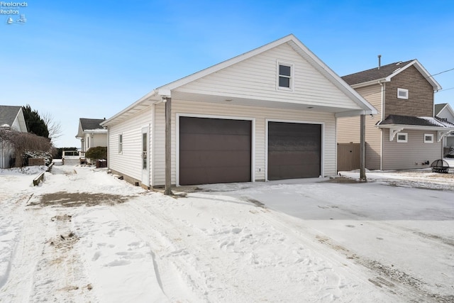 snow covered garage featuring a garage