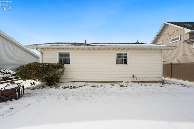 snow covered house with fence