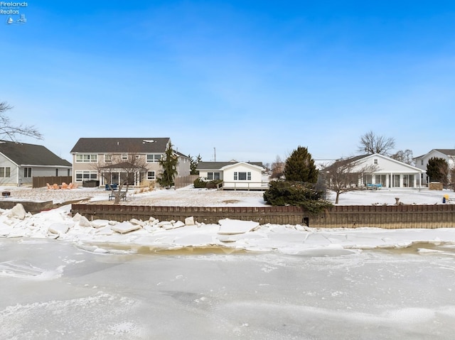 yard covered in snow featuring a residential view and fence