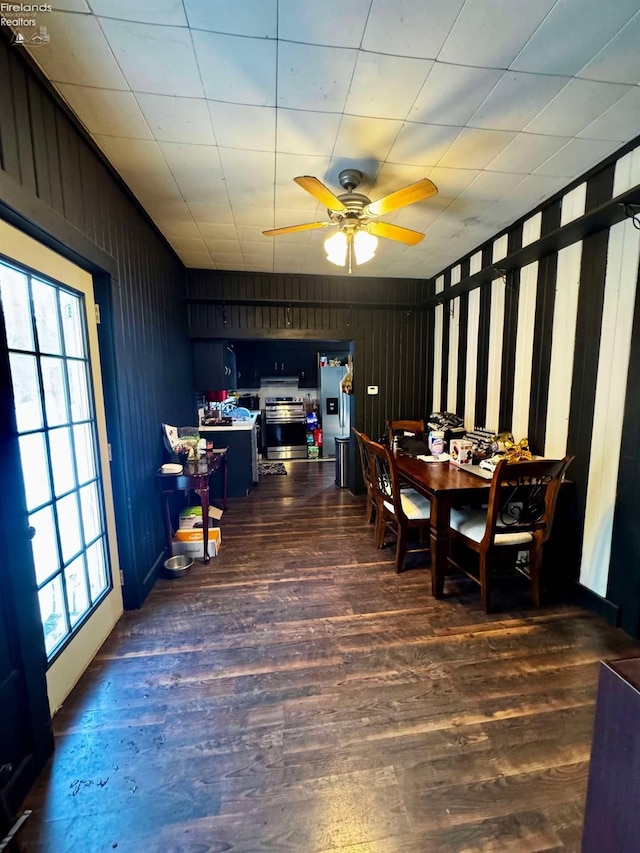 dining room with dark wood-type flooring, a ceiling fan, and a healthy amount of sunlight