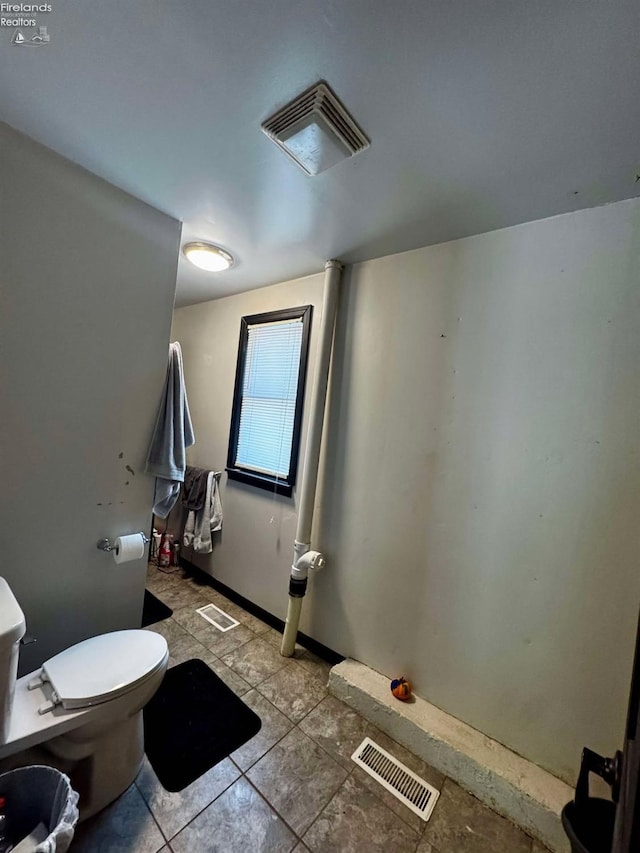 bathroom with toilet, baseboards, and visible vents