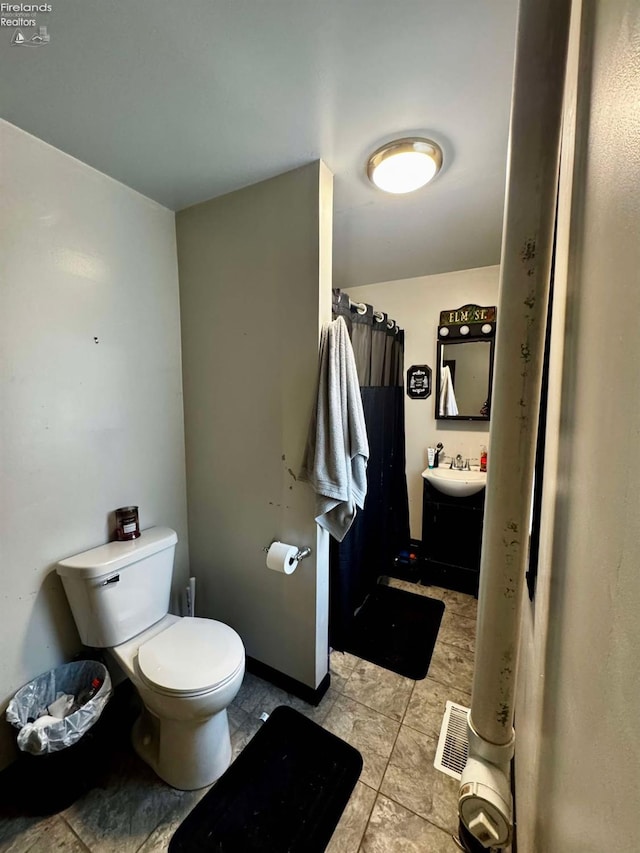 full bath with baseboards, visible vents, vanity, and toilet