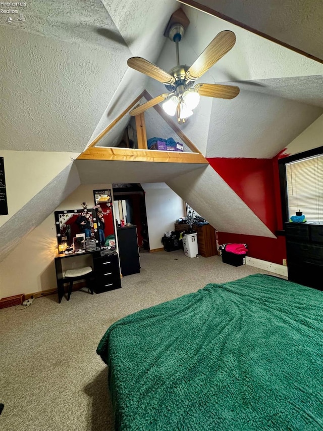 carpeted bedroom featuring a ceiling fan, vaulted ceiling, a textured ceiling, and baseboards