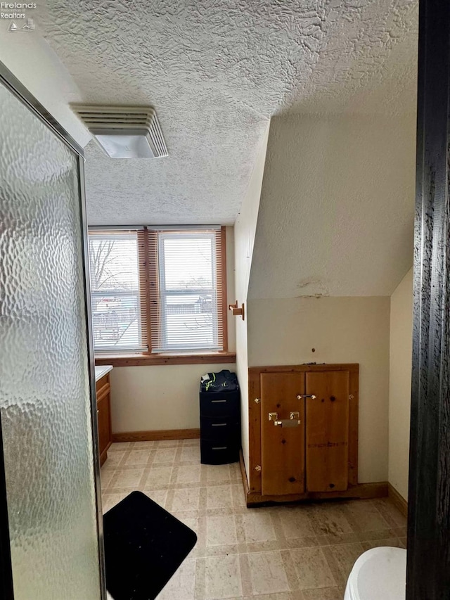 bathroom featuring a stall shower, vanity, visible vents, and baseboards