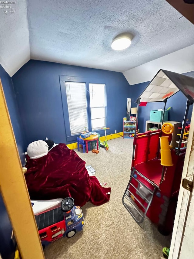 carpeted bedroom featuring lofted ceiling, baseboards, and a textured ceiling