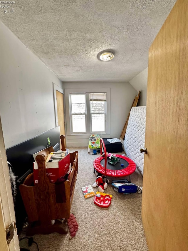 game room with carpet floors, vaulted ceiling, and a textured ceiling