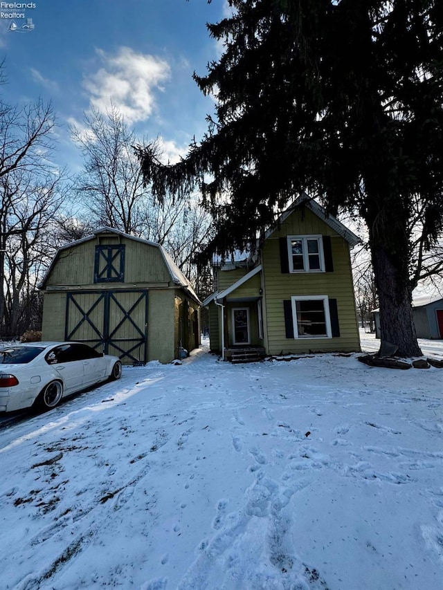 view of front of house with a garage and an outbuilding