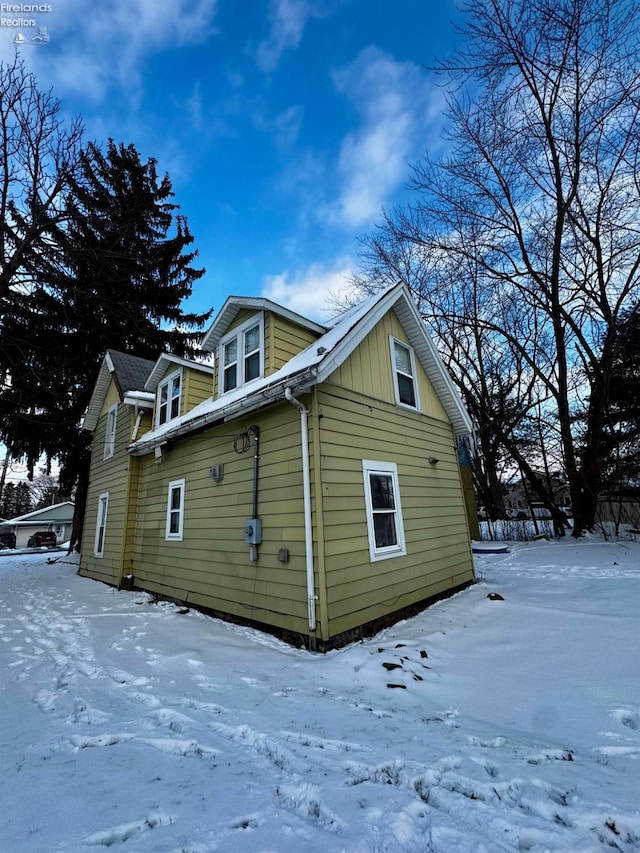 view of snow covered exterior with board and batten siding