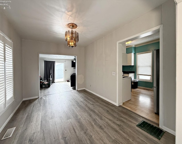 interior space with a healthy amount of sunlight, visible vents, baseboards, and wood finished floors