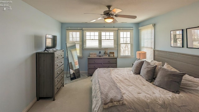 bedroom featuring baseboards, a ceiling fan, and light colored carpet