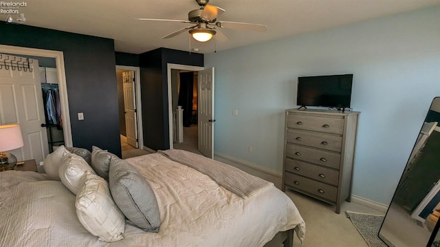 bedroom featuring a closet, light carpet, ceiling fan, and baseboards