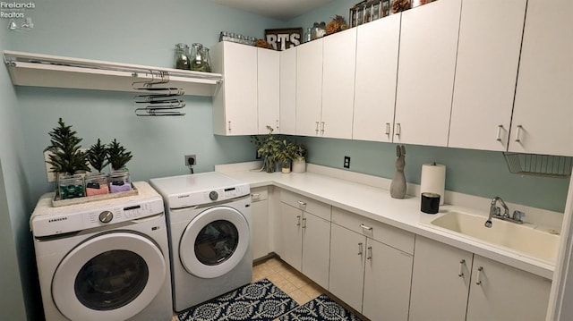 laundry room featuring cabinet space, washing machine and dryer, a sink, and light tile patterned flooring