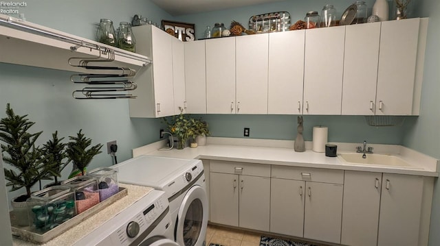 laundry area with cabinet space, a sink, and washer and clothes dryer