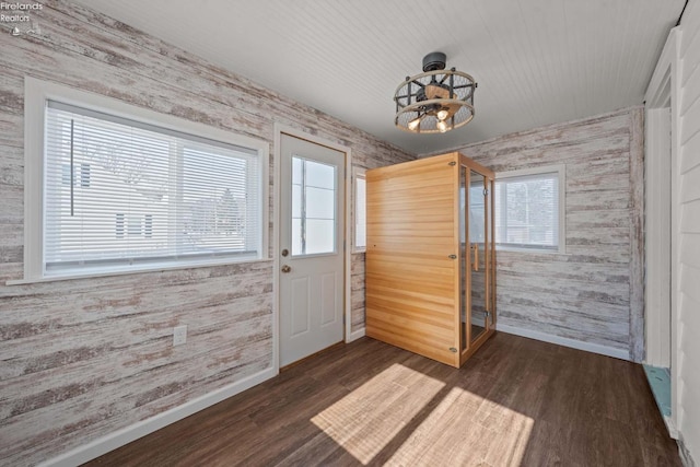 doorway with dark wood-style floors, baseboards, and wallpapered walls