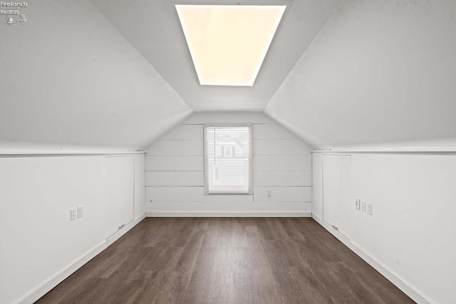 additional living space featuring baseboards, vaulted ceiling, and dark wood-style flooring